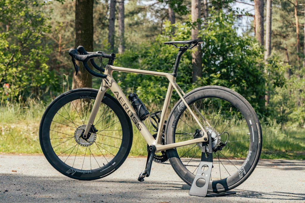 Een op maat gebouwde Aeross racefiets in het bos — bij een custom fiets kies je elk onderdeel zelf
