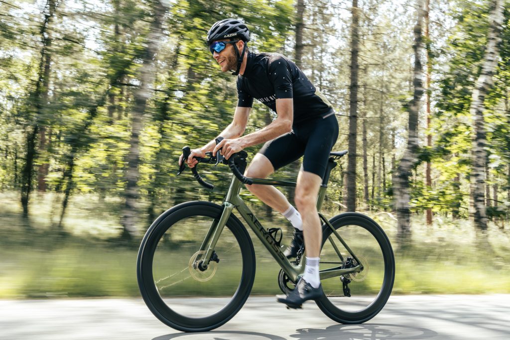 Wielrenner op een Aeross fiets door een groene omgeving — met de juiste voorbereiding haal je meer uit je eerste ritten