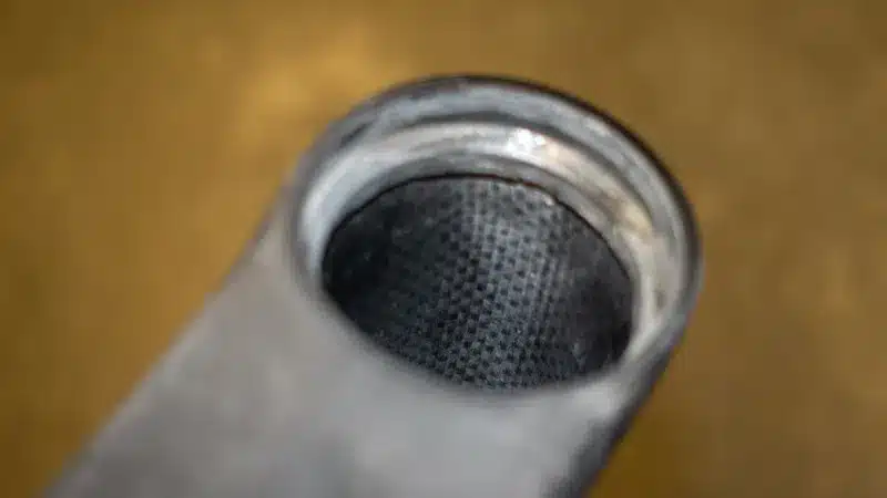 Close-up van een ongelakt carbon fietsframe — het geweven koolstofvezelpatroon is zichtbaar aan de binnenkant van de buis