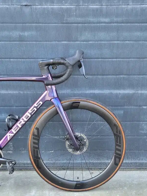 Cockpit en diepe carbon voorvelg van een Aeross racefiets, van opzij gezien
