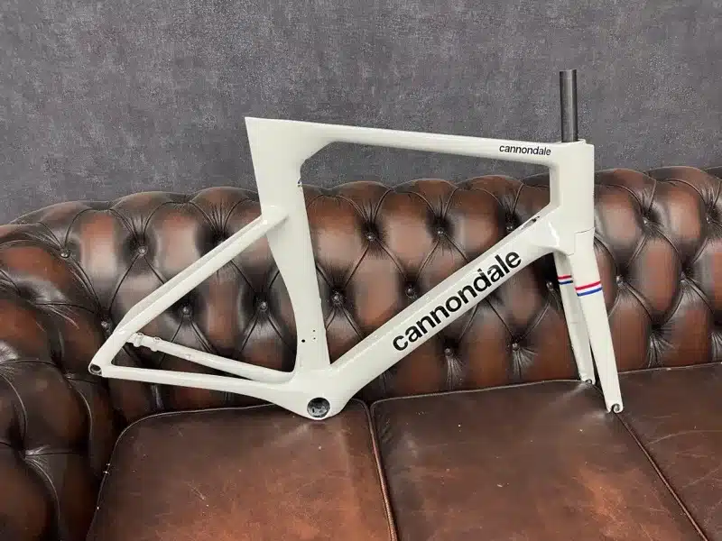 Cannondale racefietsframe lichtgrijs hoogglans gespoten bij Aeross Bikes in Valkenswaard, met Nederlandse driekleur op de vork
